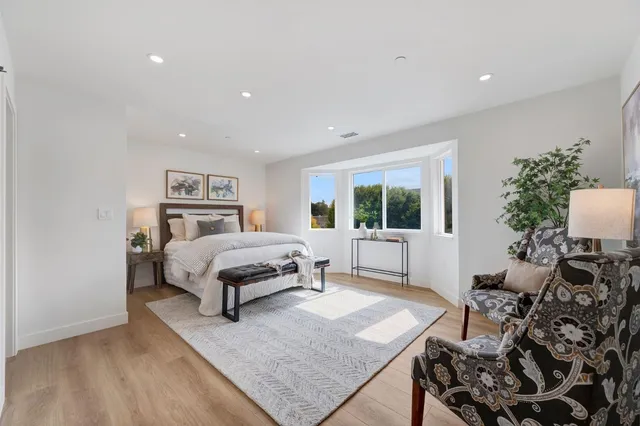 a spacious bedroom with a bed a table and a window
