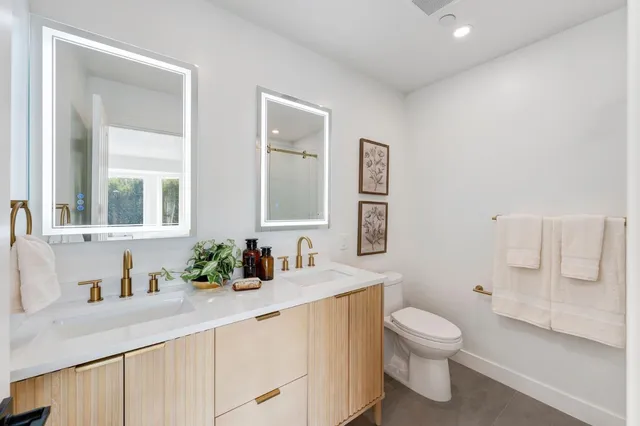 a bathroom with a granite countertop sink mirror vanity and toilet