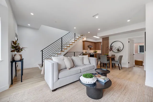 a living room with furniture kitchen and a chandelier