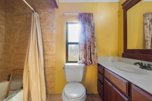 a bathroom with a granite countertop toilet sink and mirror