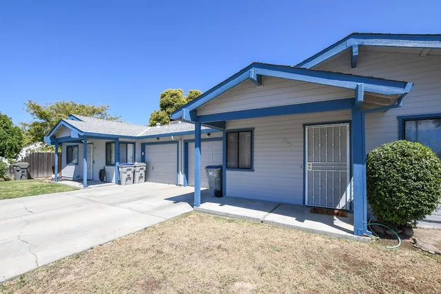 a view of a house with a yard and wooden fence