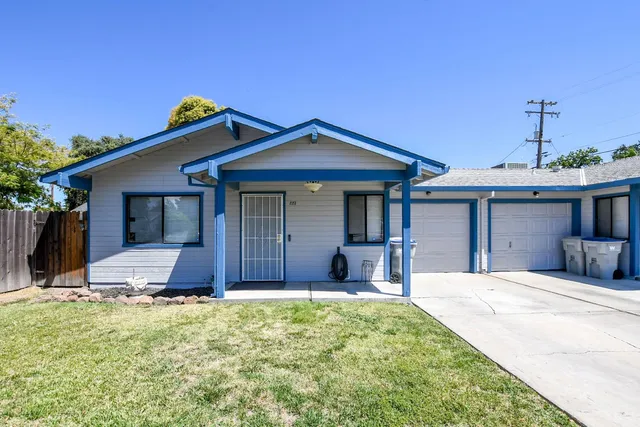 a front view of a house with a yard and seating space