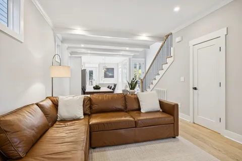 a kitchen with stainless steel appliances a refrigerator a sink a stove a dining table and chairs