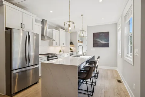a kitchen with a stove a sink and a wooden floor