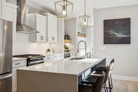 a kitchen with stainless steel appliances granite countertop a stove a sink and a refrigerator