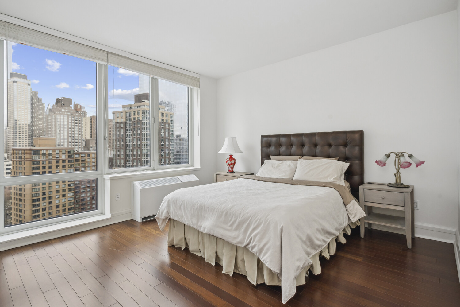 60 Riverside Boulevard, Unit 1806 Manhattan, NY 10069 - Photo 6 of 16 a bedroom with a large bed and a window