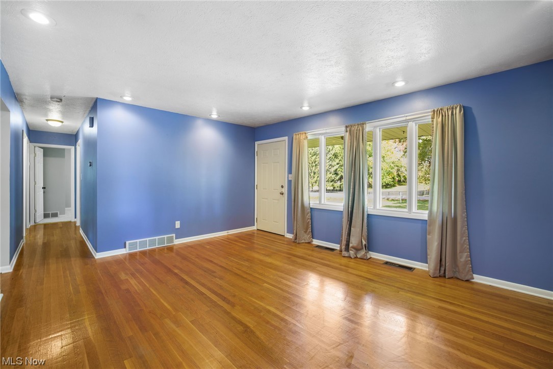 730 East Nimisila Road Uniontown, OH 44685 - Photo 8 of 25 Unfurnished room featuring light wood-type flooring and a textured ceiling