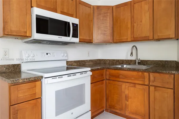 a kitchen with stainless steel appliances granite countertop a sink stove and microwave