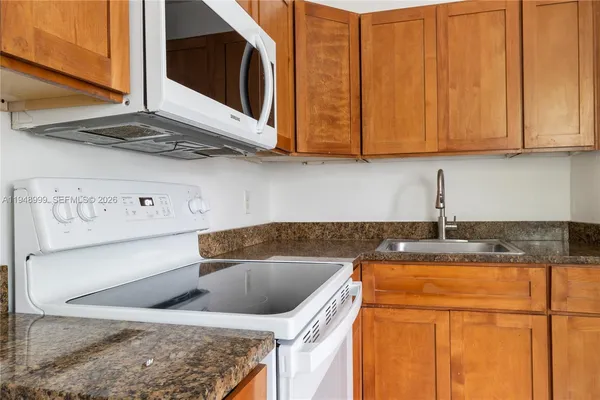 a kitchen with stainless steel appliances granite countertop a sink a stove and a microwave