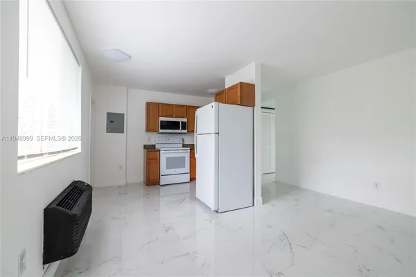 a view of kitchen with refrigerator cabinets and furniture