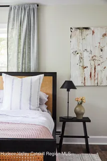 a bedroom with a bed and a lamp on dresser