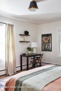 a bedroom with a bed and a large window