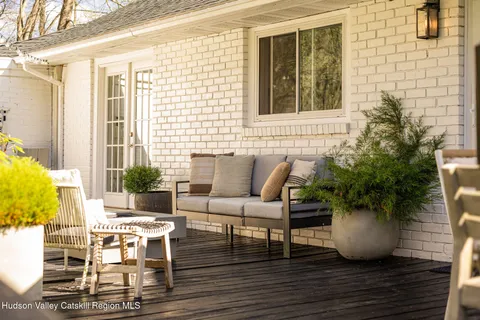 a roof deck with table and chairs and potted plants