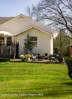 a view of a house with backyard and sitting area