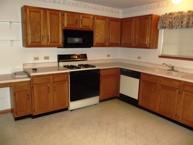 869 Golf Course Road, Unit 2 Crystal Lake, IL 60014 - Photo 5 of 11 a kitchen with sink a microwave a stove and cabinets