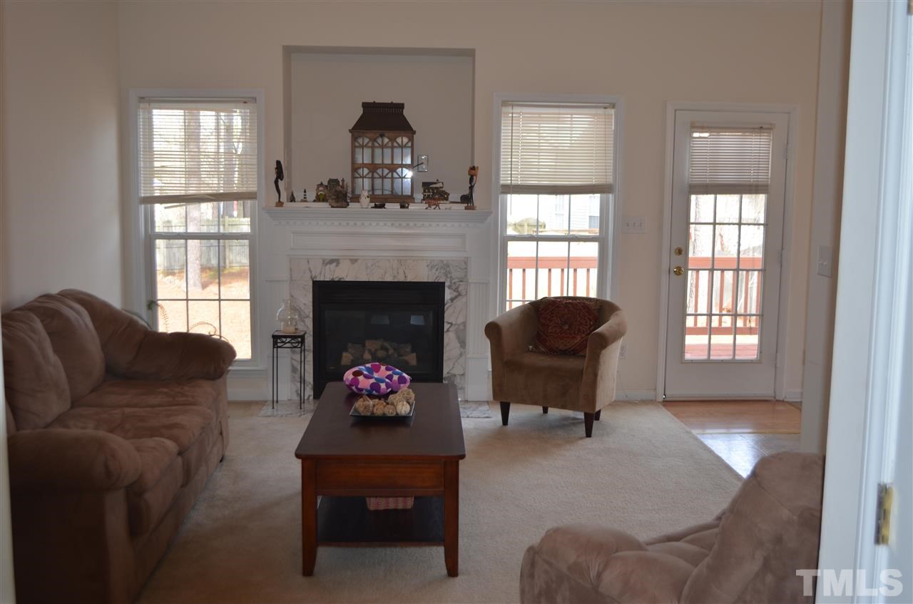 7137 Spanglers Spring Way Raleigh, NC 27610 - Photo 2 of 8 a living room with furniture a fireplace and windows