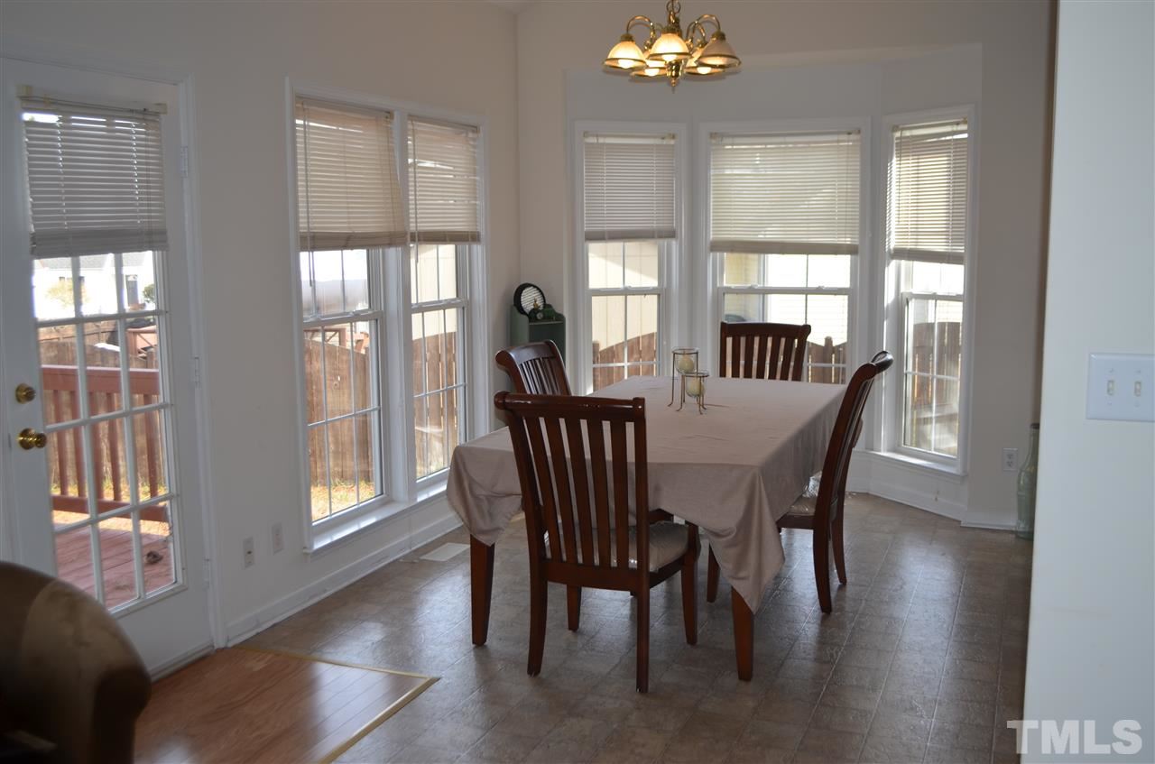 7137 Spanglers Spring Way Raleigh, NC 27610 - Photo 3 of 8 a view of a dining room with furniture window and wooden floor