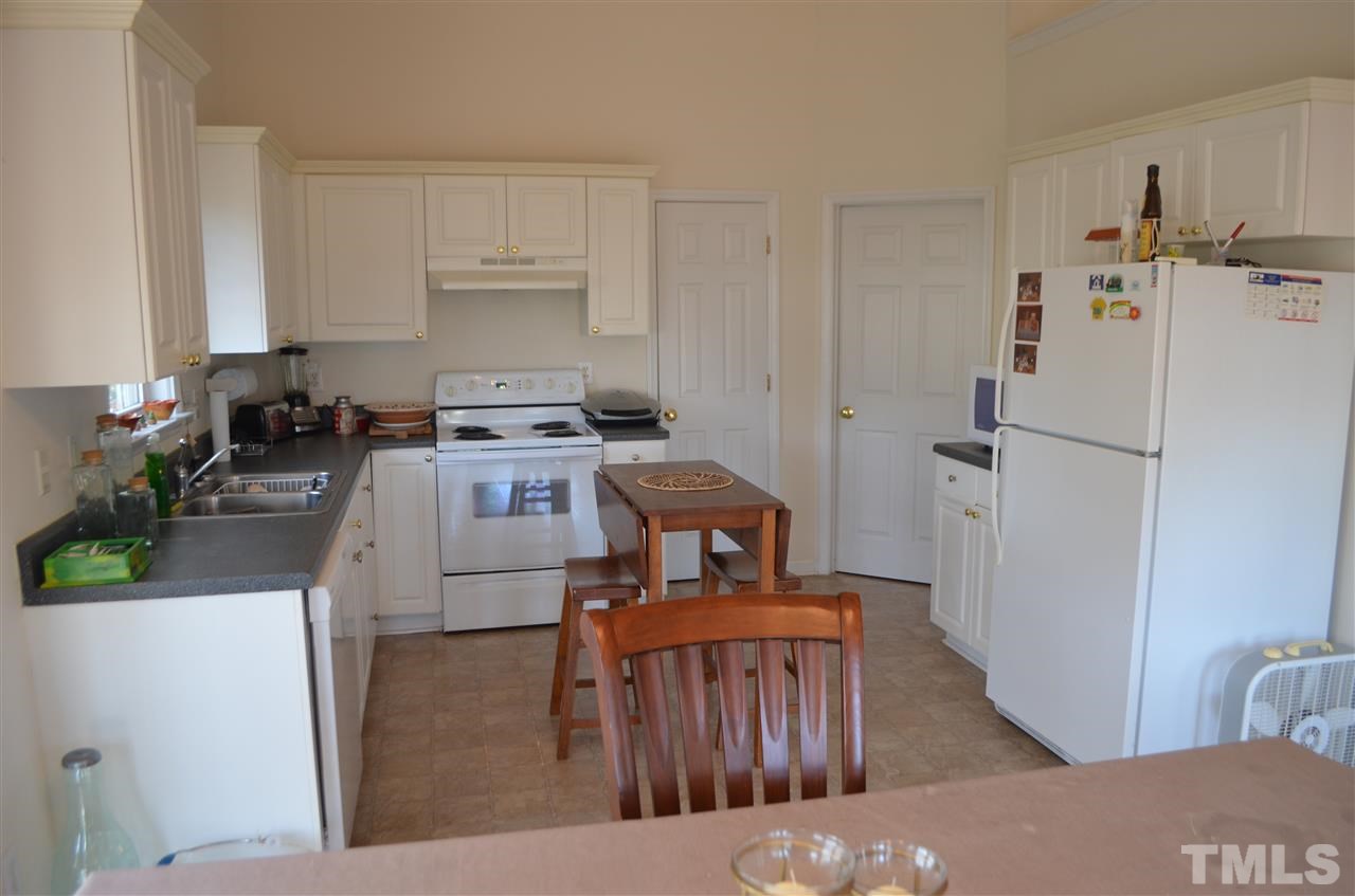 7137 Spanglers Spring Way Raleigh, NC 27610 - Photo 4 of 8 a kitchen with a refrigerator a stove top oven a sink and dishwasher