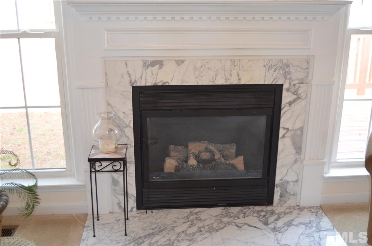 7137 Spanglers Spring Way Raleigh, NC 27610 - Photo 5 of 8 a fireplace with a wooden floor