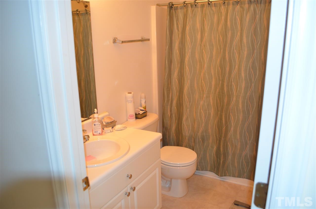 7137 Spanglers Spring Way Raleigh, NC 27610 - Photo 6 of 8 a bathroom with a sink a toilet and shower curtain