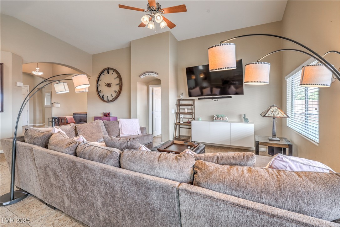 172 Turtle Ridge Avenue Las Vegas, NV 89183 - Photo 14 of 38 Living area with tile patterned flooring, arched walkways, lofted ceiling, and ceiling fan