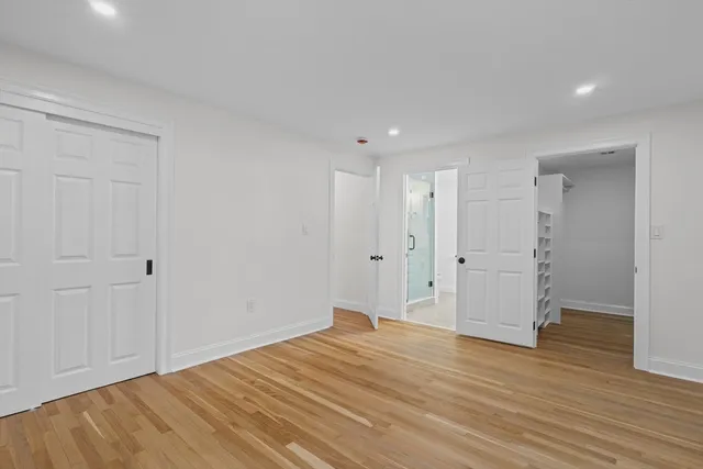 a view of empty room with wooden floor