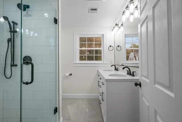 a bathroom with a sink a mirror and shower