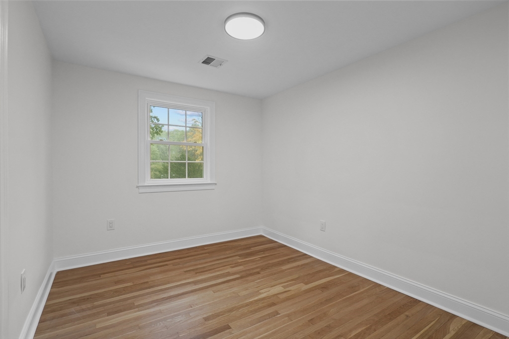217 Central Street Framingham, MA 01701 - Photo 22 of 42 an empty room with wooden floor and windows