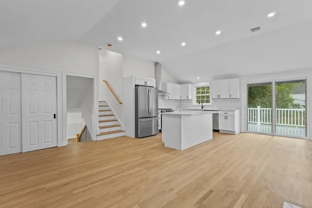 a view of a kitchen with wooden floor and electronic appliances