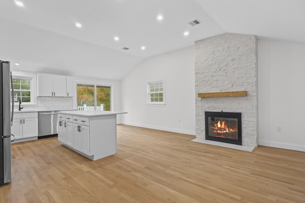 217 Central Street Framingham, MA 01701 - Photo 5 of 42 a kitchen with stainless steel appliances granite countertop a stove top oven a sink dishwasher and a fireplace with wooden floor