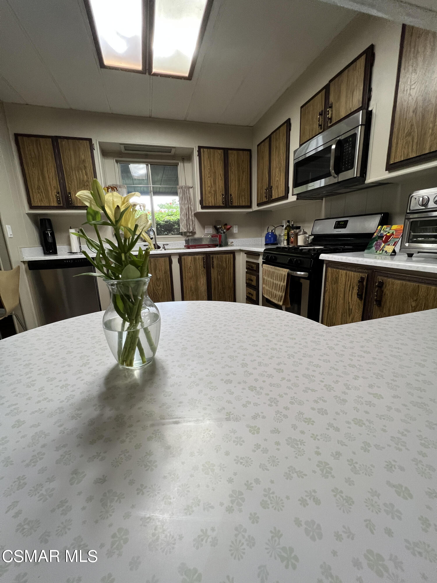 1550 Rory Lane, Unit 83 Simi Valley, CA 93063 - Photo 18 of 50 a kitchen with stainless steel appliances a sink a stove and a refrigerator