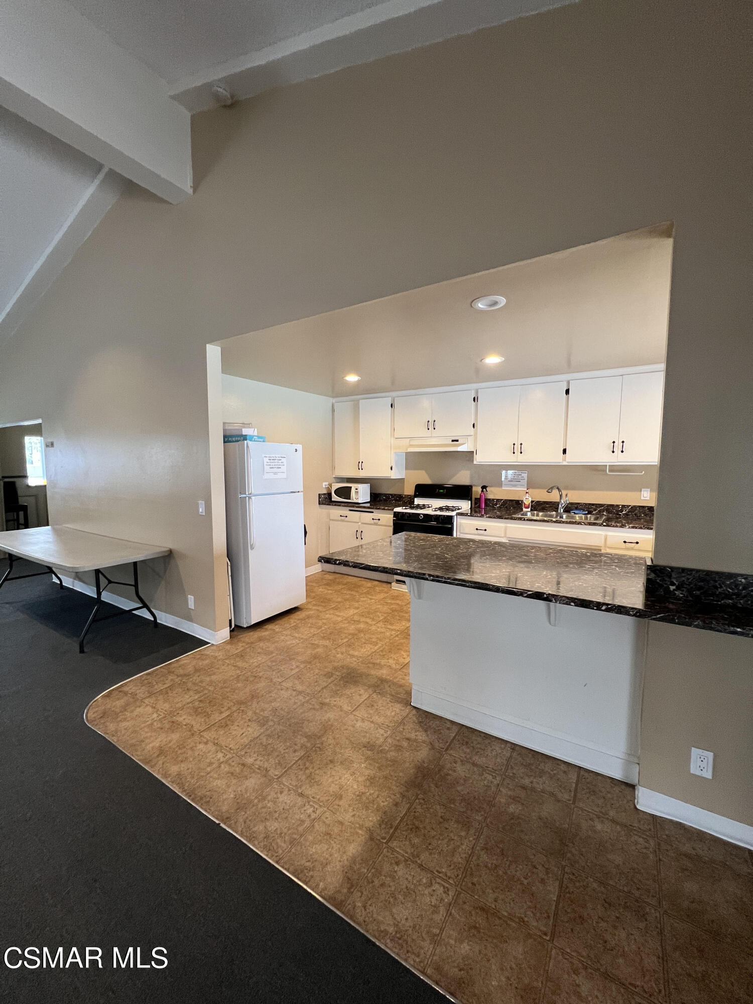 1550 Rory Lane, Unit 83 Simi Valley, CA 93063 - Photo 38 of 50 a kitchen with stainless steel appliances granite countertop a refrigerator a stove a sink dishwasher with a dining table and chair