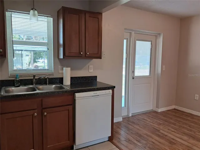 a kitchen with stainless steel appliances granite countertop wooden cabinets a sink and dishwasher
