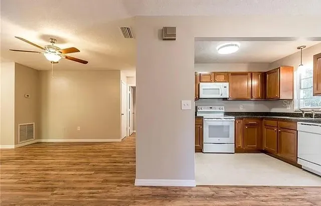 a view of a kitchen with a sink and dishwasher a kitchen island with wooden floor