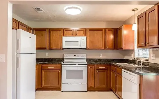 a kitchen with a stove a sink and a refrigerator