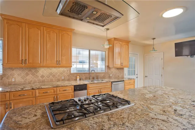 a kitchen with stainless steel appliances granite countertop a stove a sink and a refrigerator