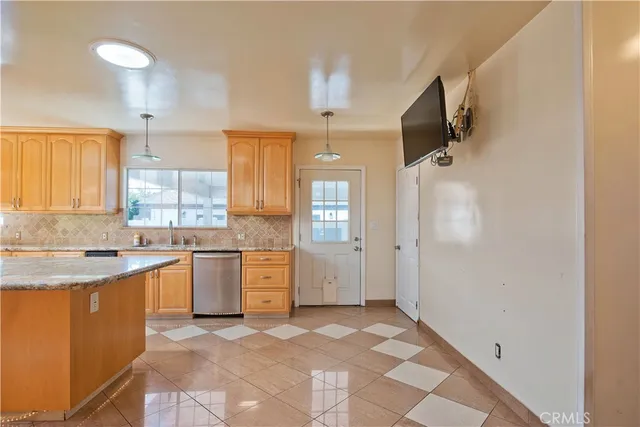 a large kitchen with a stove a sink dishwasher a refrigerator and a fireplace with wooden floor