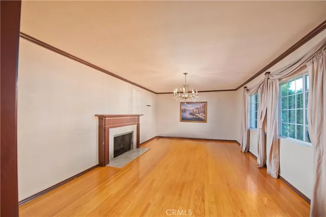 a view of empty room with fireplace and wooden floor