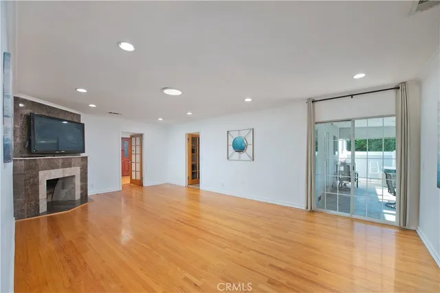 a view of empty room with wooden floor and fireplace