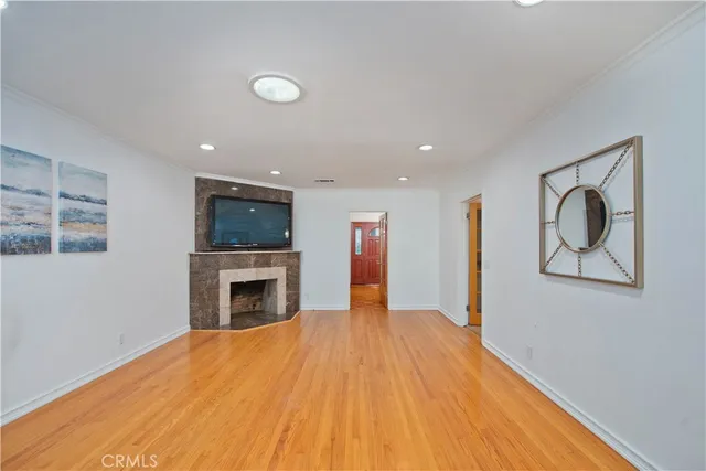 a view of empty room with fireplace and wooden floor
