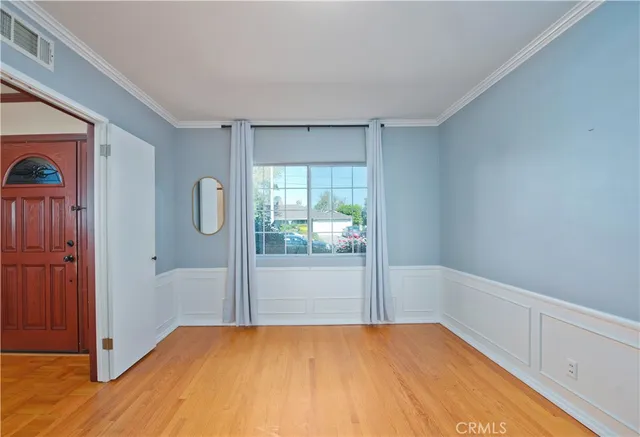 a view of a room that has wooden floor and windows