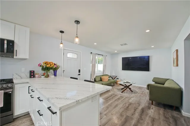 a living room with kitchen island furniture and a flat screen tv