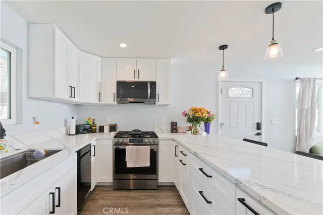 a kitchen with stainless steel appliances granite countertop a sink a stove and cabinets