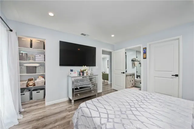 a bedroom with furniture and a flat screen tv