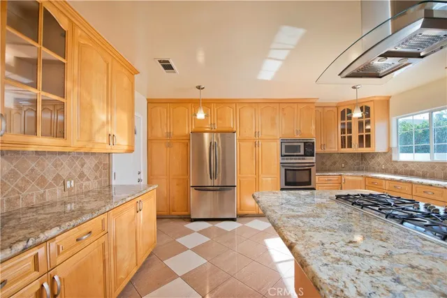a kitchen with stainless steel appliances granite countertop a refrigerator and a sink