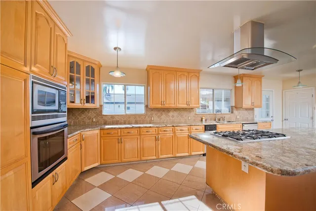 a kitchen with stainless steel appliances granite countertop a stove a sink and a refrigerator