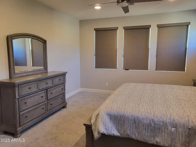 a bedroom with a bed and a mirror on dresser