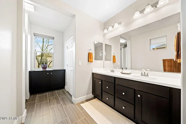 a spacious bathroom with a double vanity sink and a mirror