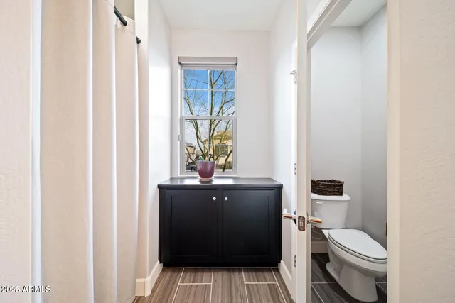 a bathroom with a toilet a sink and a window