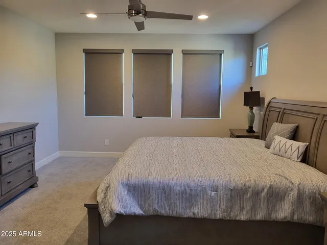 a bedroom with a bed and painting on the wall